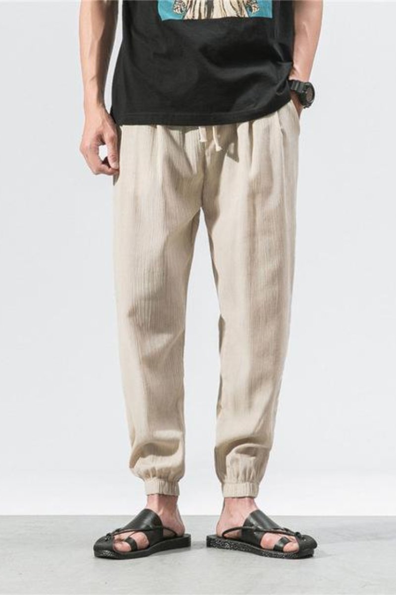 Pantaloni jogger uomo streetwear beige, stile harem, vita elastica e vestibilità comoda.