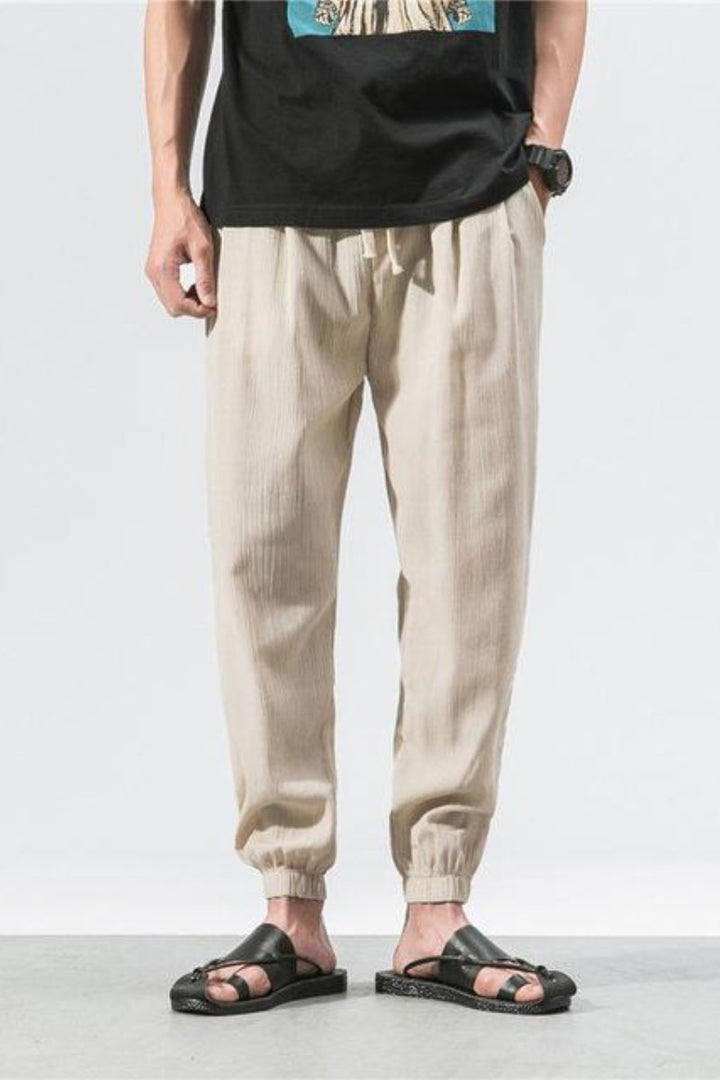 Pantaloni jogger uomo streetwear beige, stile harem, vita elastica e vestibilità comoda.