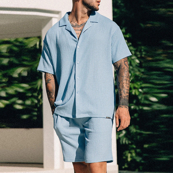 Uomo in completo estivo streetwear: t-shirt stampata e pantaloncini. Outfit casual per un look urbano.
