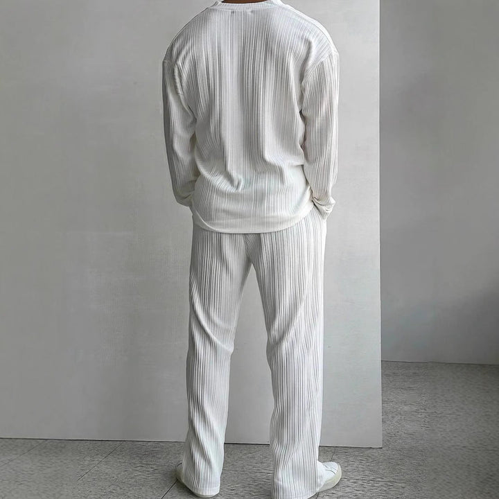 Dettaglio completo uomo casual elegante nero. Camicia e pantaloni tinta unita, abbigliamento di qualità e comfort.