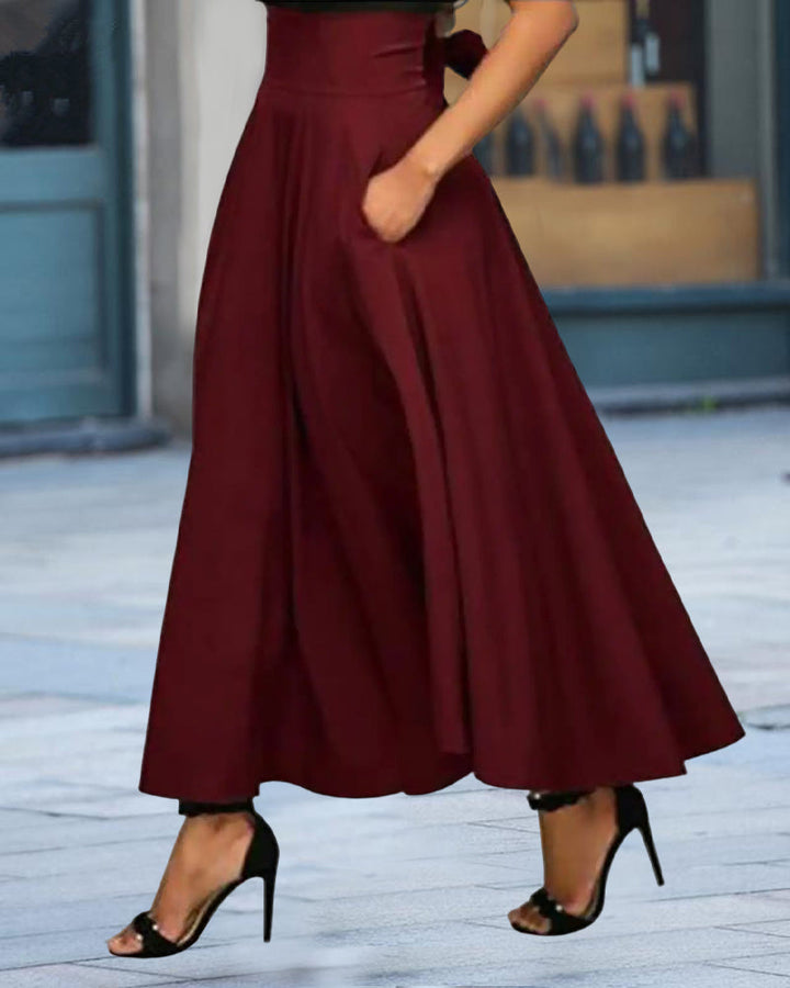Gonna midi nera elegante da donna con vita alta, ideale per outfit autunnali e primaverili.