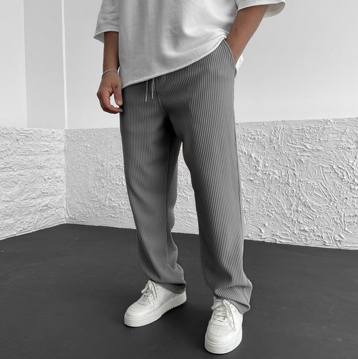 Uomo indossa pantaloni comodi a vita regolabile per streetwear. Look versatile e moderno, moda uomo casual.