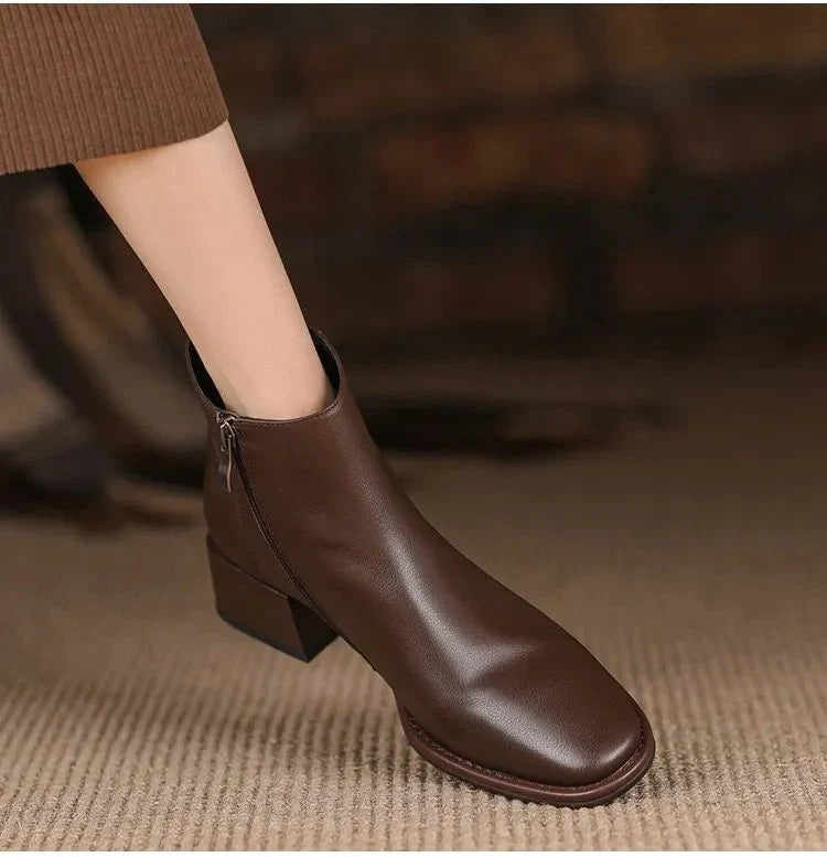 Coppia di stivali donna in pelle, neri, con tacco basso. Stivaletti comodi e chic, perfetti per outfit eleganti.