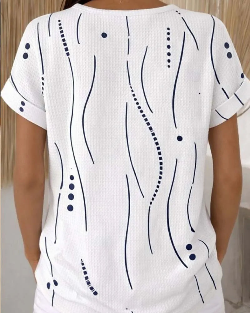 T-shirt donna bianca casual con stampa grafica e bottoni. Perfetta per look estivi e outfit quotidiani.