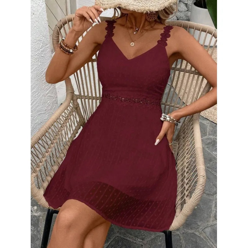 Abito mini donna estivo plumetis con pizzo, disteso su sfondo neutro. Moda femminile, vestito elegante.