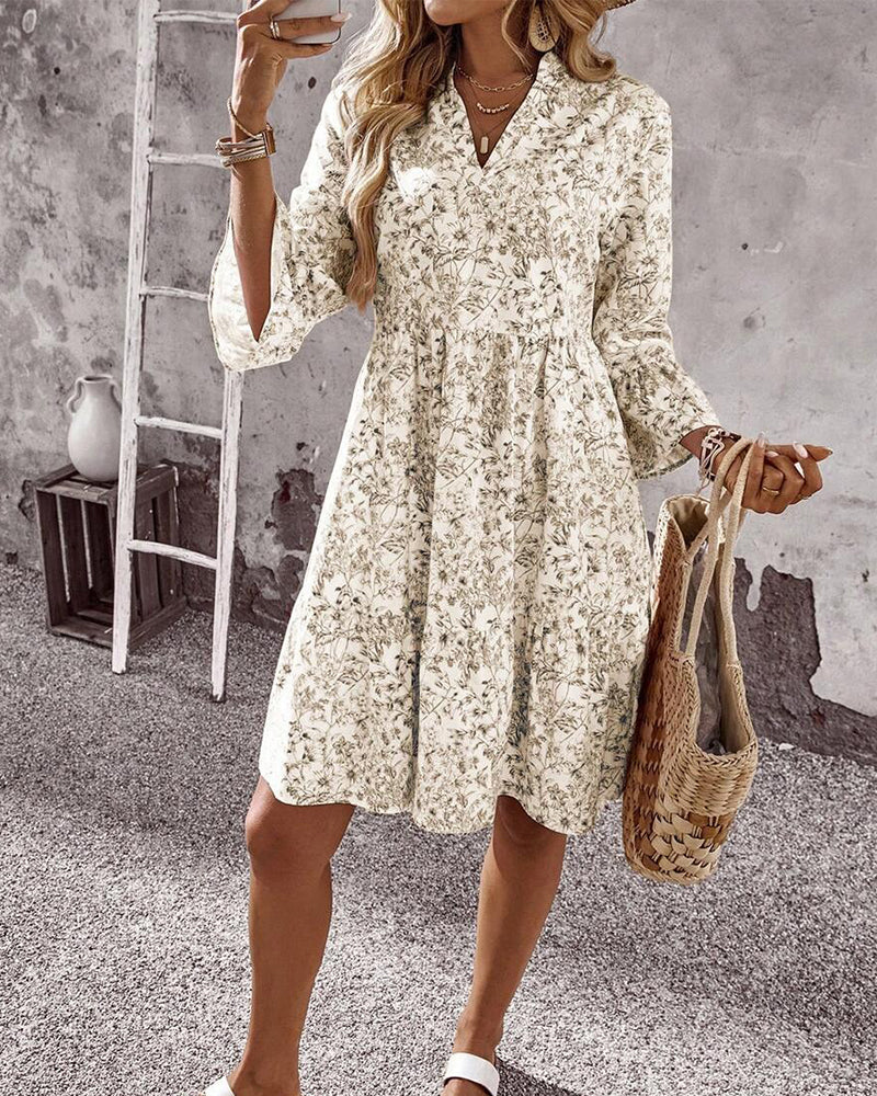 Primo piano abito primaverile donna beige con delicata stampa floreale, collo alto e maniche a volant.