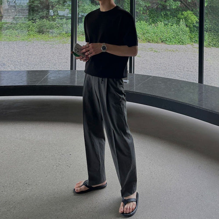 Modello indossa pantaloni uomo casual grigi per un look streetwear raffinato, gamba dritta e vestibilità comoda.