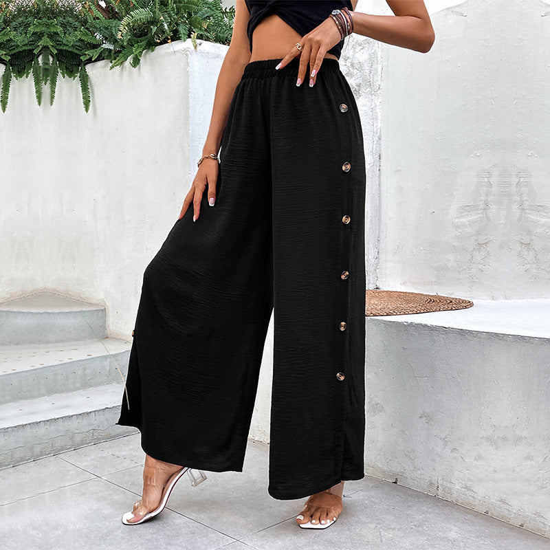 Pantaloni donna vita alta neri, dal taglio a gamba larga con spacchi laterali. Eleganza e design contemporaneo.
