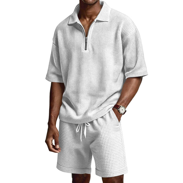 Polo a maniche corte con zip e pantaloncini abbinati. Completo estivo uomo casual e confortevole.