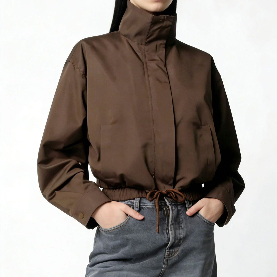 Trench donna minimalista con collo alto e maniche lunghe. Cappotto lungo elegante, ideale per la moda mezza stagione.