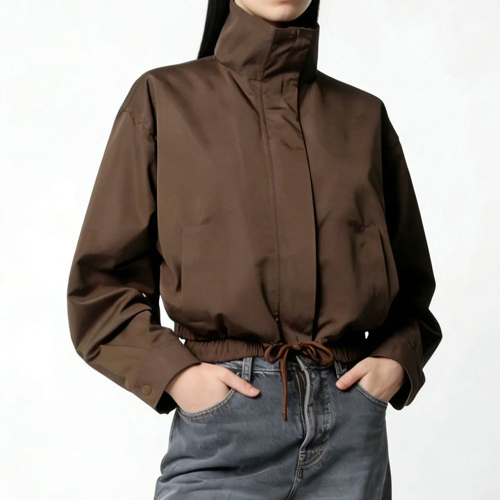 Trench donna minimalista con collo alto e maniche lunghe. Cappotto lungo elegante, ideale per la moda mezza stagione.