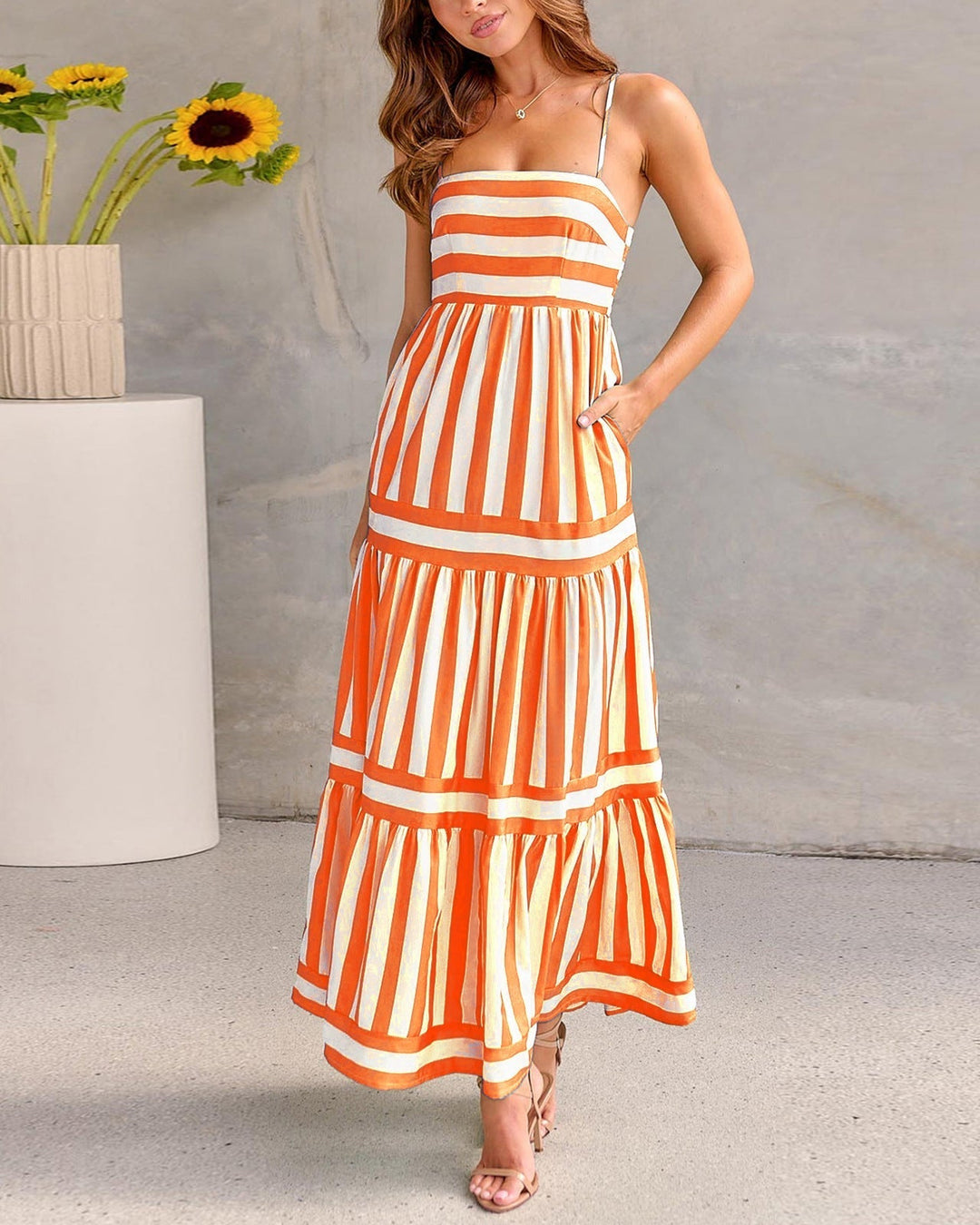 Abito donna lungo a righe con scollo quadrato, schiena scoperta e pratiche tasche. Eleganza estiva per ogni occasione.