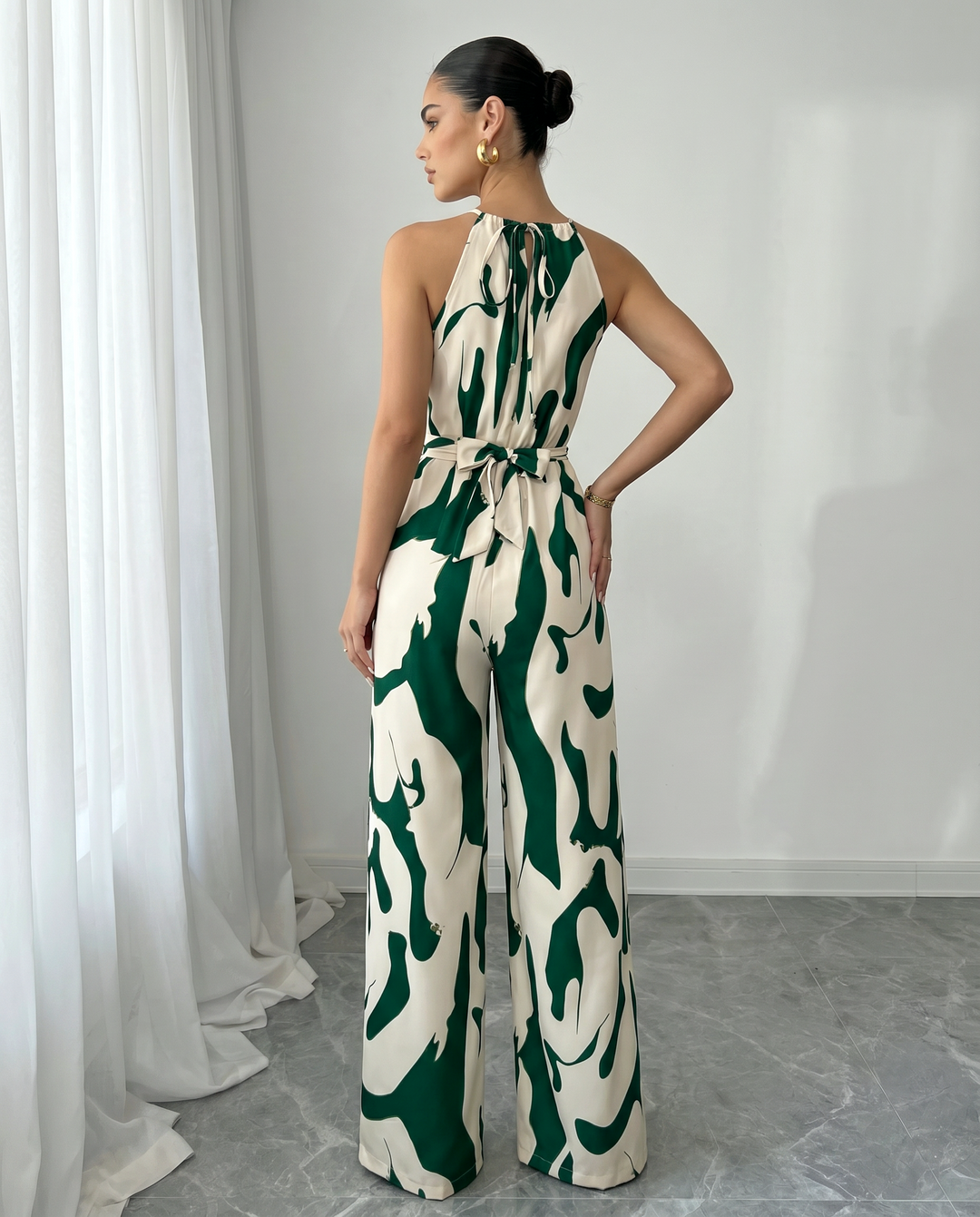 Tuta donna elegante con stampa astratta unica, scollo halter. Look fluido e sofisticato.