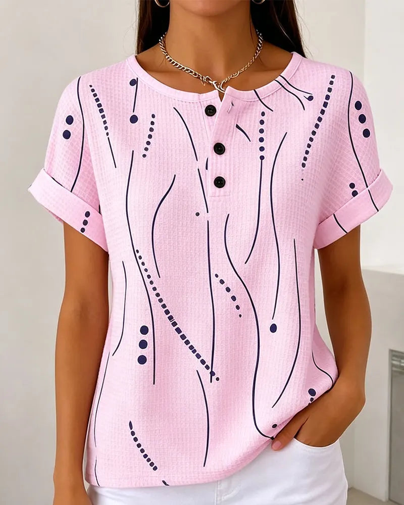 T-shirt donna casual rosa, nera e bianca con stampa grafica e bottoni. Abbigliamento versatile primavera estate.