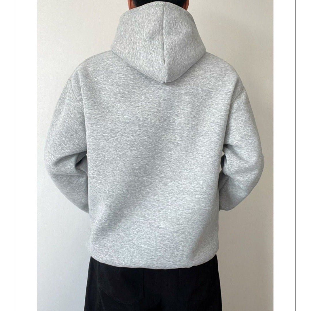 Uomo indossa felpa con cappuccio grigia, vestibilità ampia. Stile rilassato per un outfit comodo e versatile.