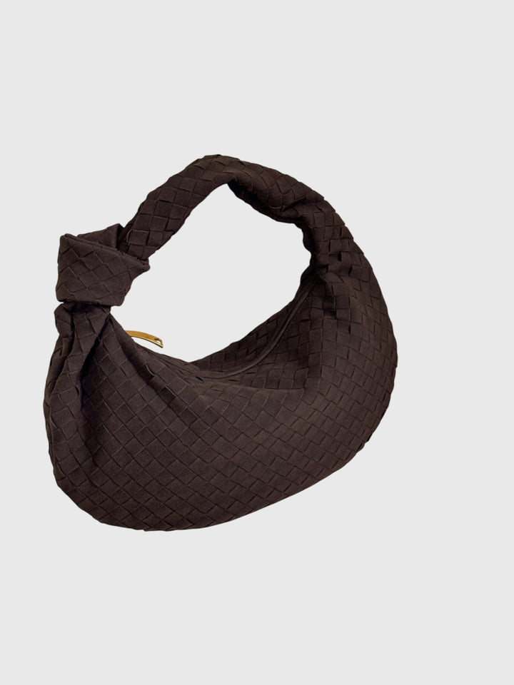 Accessorio di moda femminile: borsa in suede intrecciato con nodo, versatile e chic.