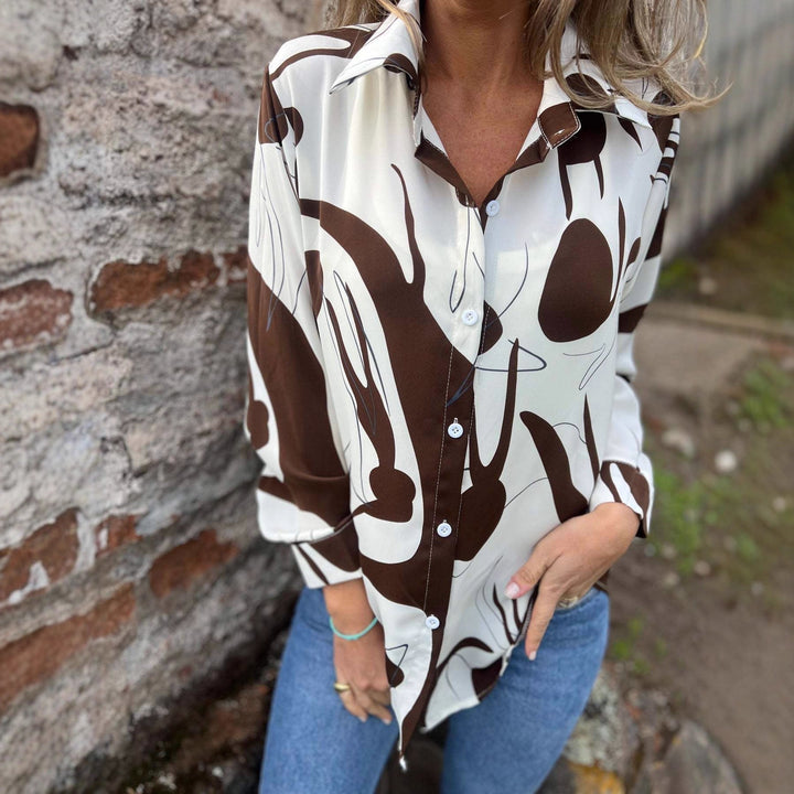 Camicia versatile da donna a manica lunga, con stampa 3D. Ideale per stile casual o elegante, disponibile nera o marrone.