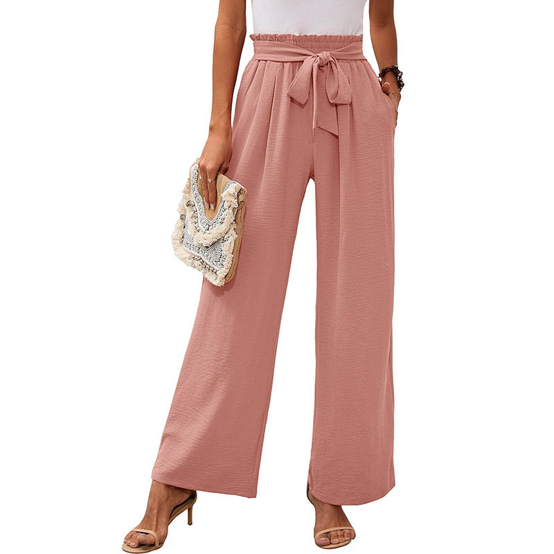Vista laterale: pantaloni donna eleganti con nodo in vita, gamba ampia. Silhouette fluida.