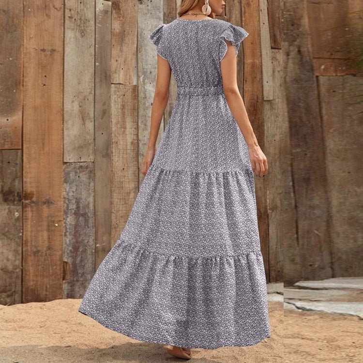 Donna in elegante abito lungo bohemien con scollo a V e vivace stampa floreale. Ideale per l'estate.