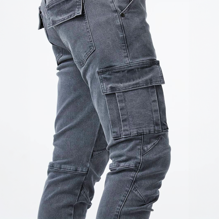 Dettaglio jeans cargo uomo slim fit con cuciture a contrasto e tasche ampie, stile moda uomo.