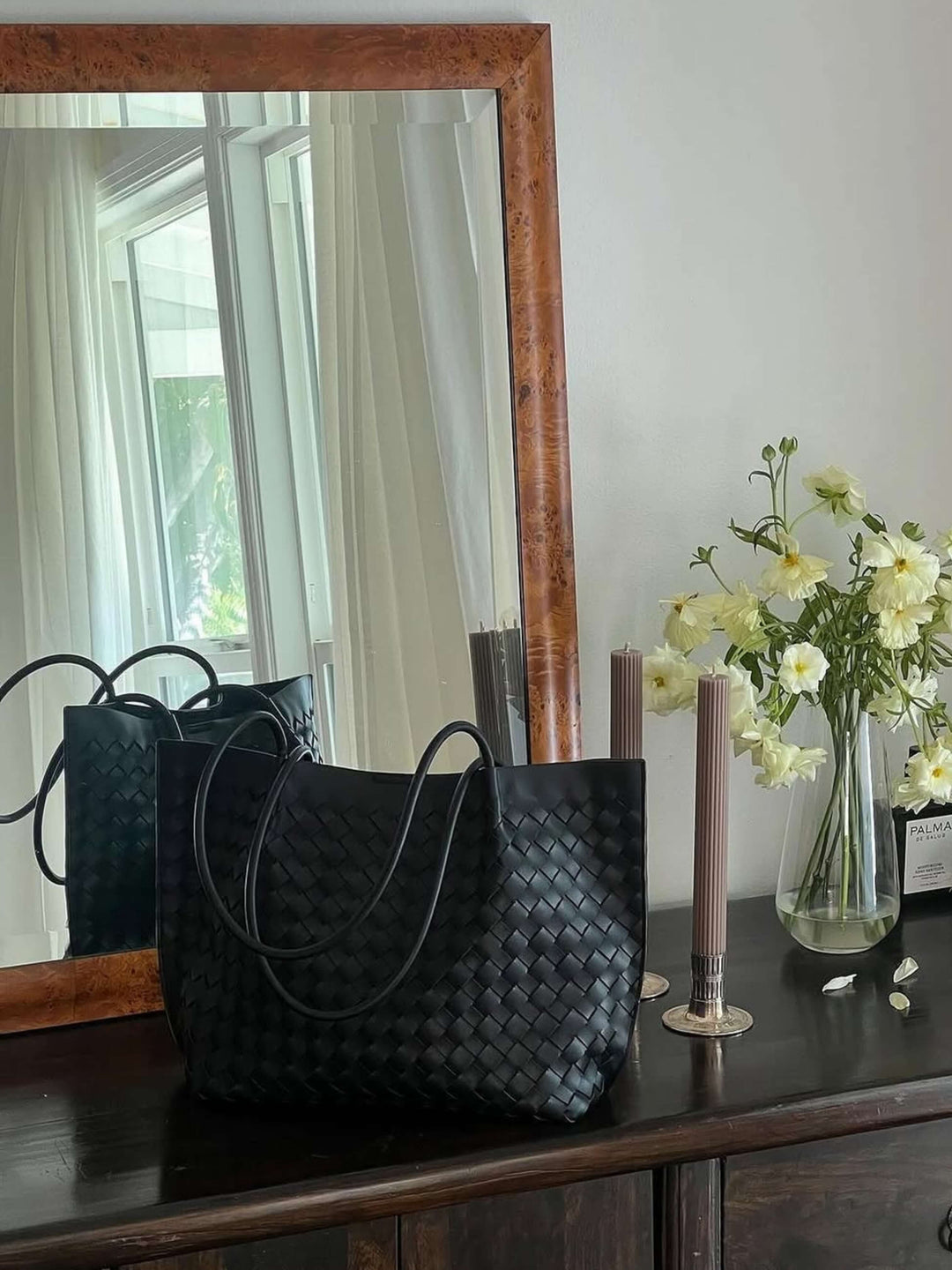Borsa tote intrecciata da donna su sfondo chiaro, mostra la sua capienza e design chic.