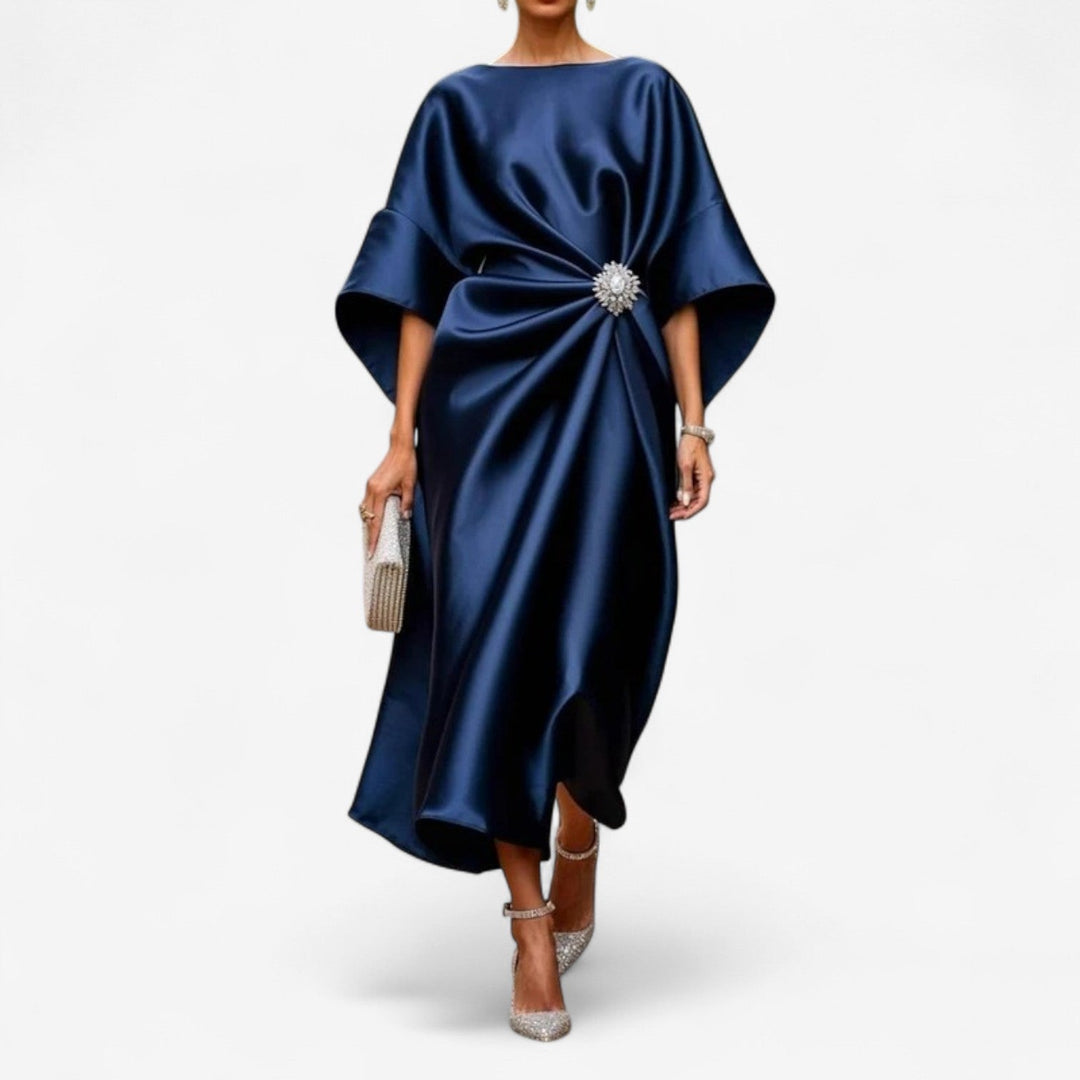Abito drappeggiato donna blu scuro, con eleganti maniche a pipistrello e spilla gioiello, ideale per cerimonia.