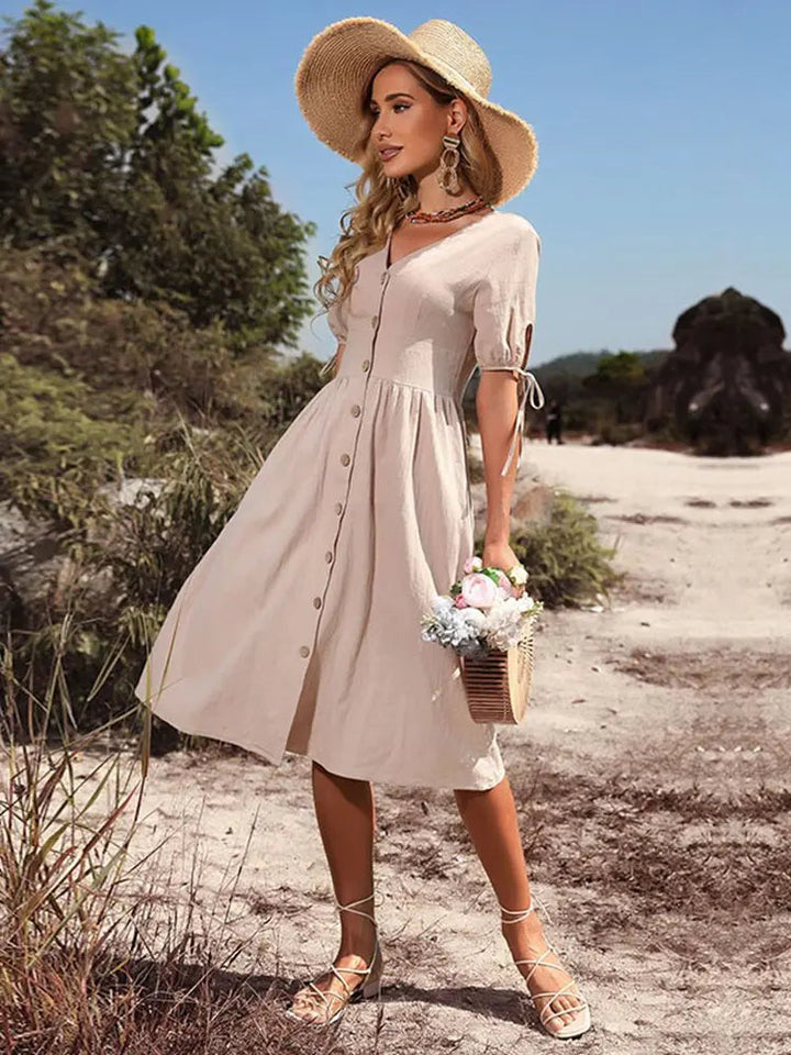 Abito donna midi estivo con bottoni frontali, scollatura a V e maniche a palloncino. Look chic per vacanze.