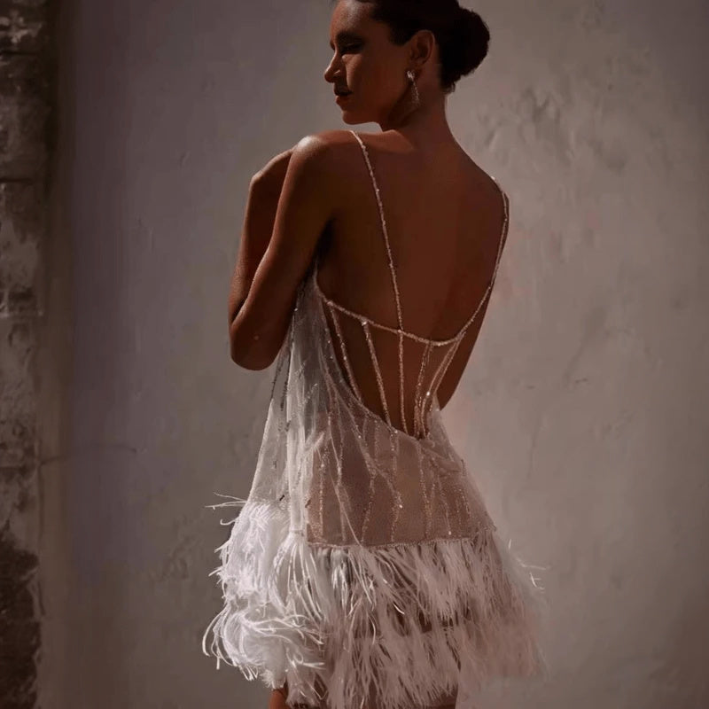 Mini abito estivo bianco donna con frange luccicanti, un vestito alla moda e chic. Design fluido e contemporaneo.