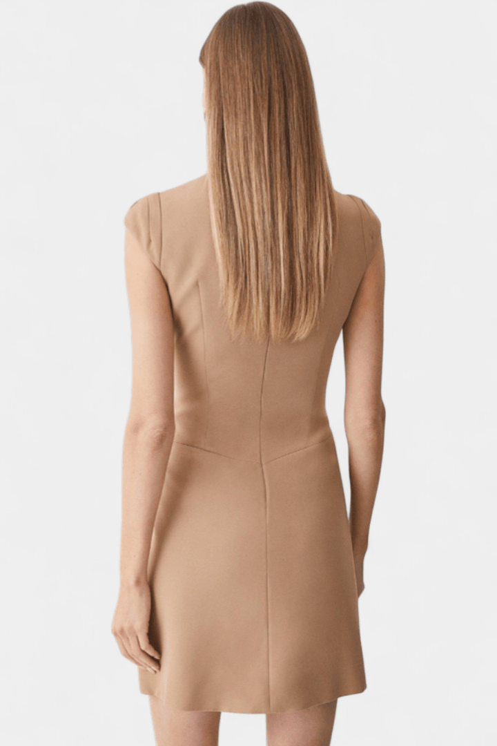 Donna in abito plissettato con orlo a ruota, vestibilità elegante e design moderno.