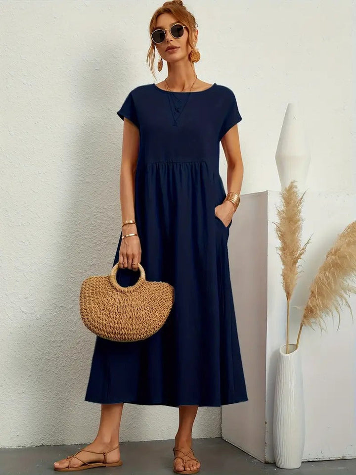 Elegante abito midi donna fluido con tasche laterali, ideale per comfort e stile in look casual.