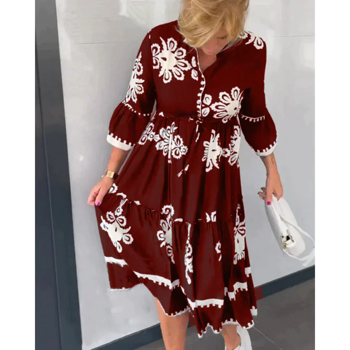Profilo di donna che sfoggia un abito fluido midi con fantasia floreale, accentuato dalla cintura regolabile e stile.