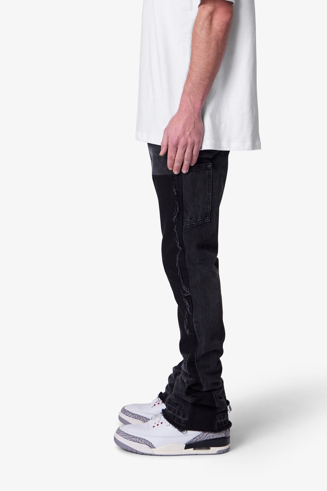 Dettaglio pantaloni uomo neri a zampa slim fit. Stile workwear, con pannelli. Per un look casual elegante moderno.