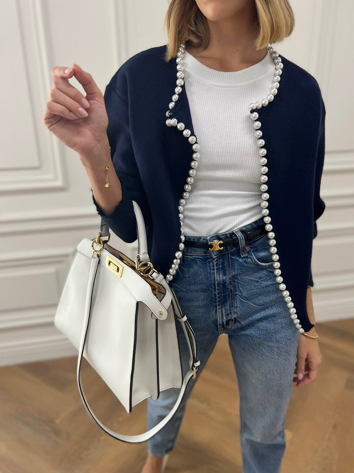Modella indossa cardigan donna elegante con perle e maniche lunghe. Abbigliamento versatile chic.