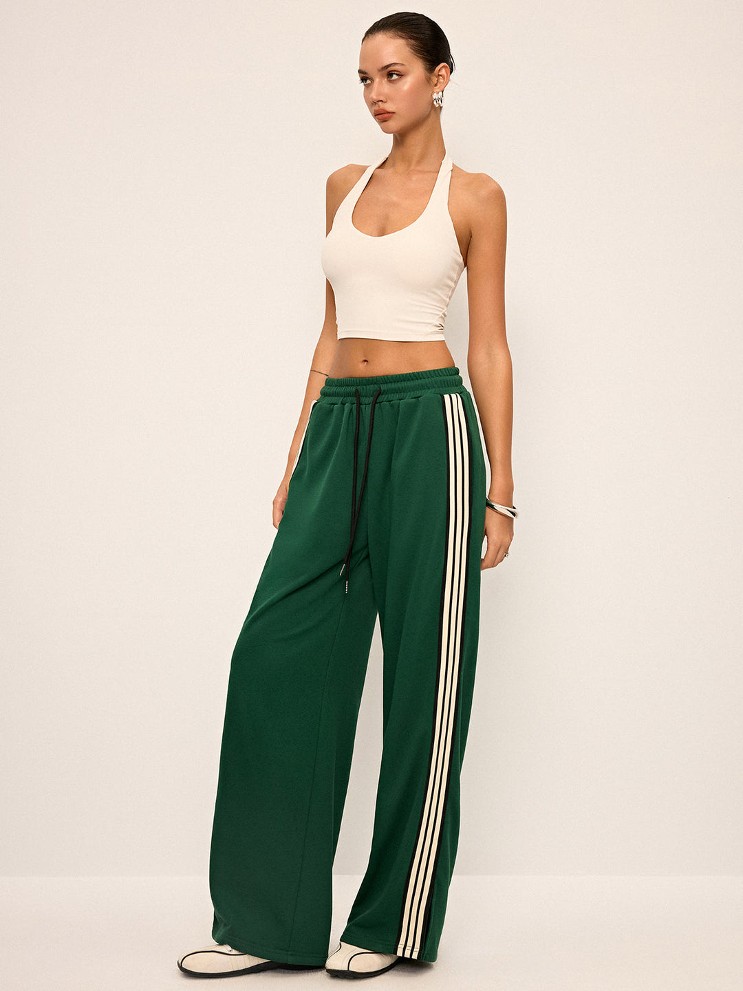 Pantaloni donna stile tuta con vestibilità rilassata a gamba larga e iconica banda laterale.