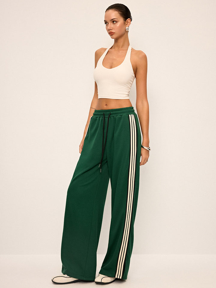 Pantaloni donna stile tuta con vestibilità rilassata a gamba larga e iconica banda laterale.