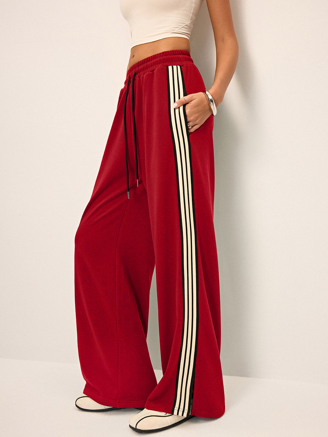 Eleganti pantaloni donna a gamba larga, stile tuta, con distintiva banda laterale per comfort quotidiano.