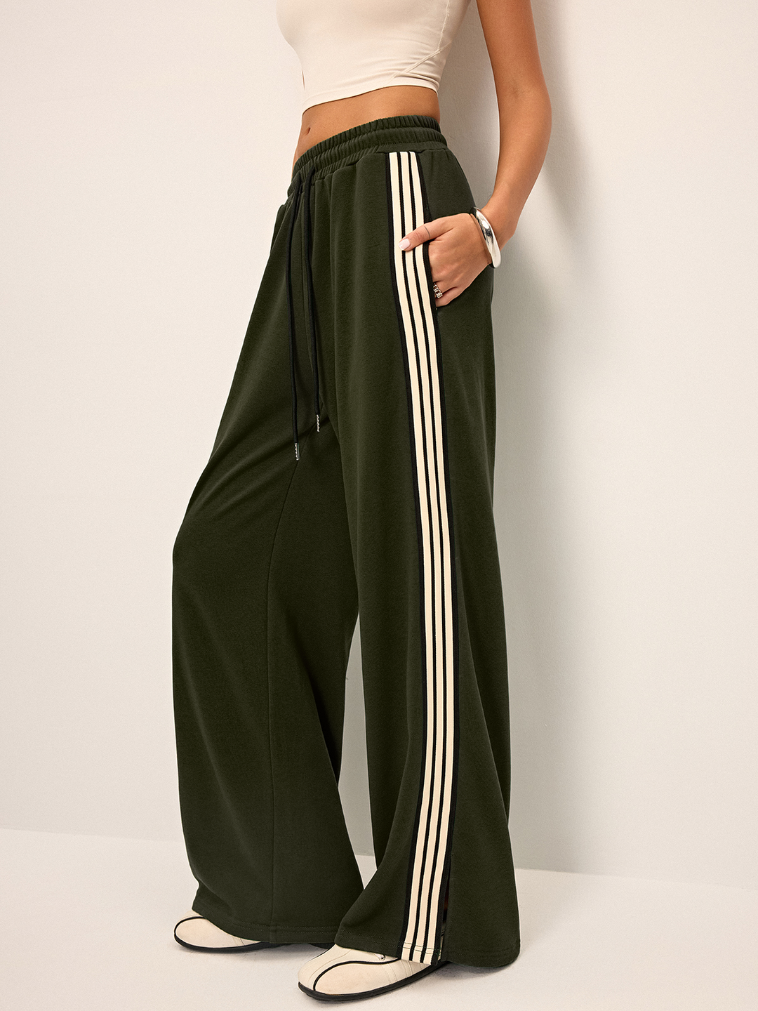 Moderni pantaloni tuta donna a gamba larga, con banda laterale che unisce comfort e tendenza.