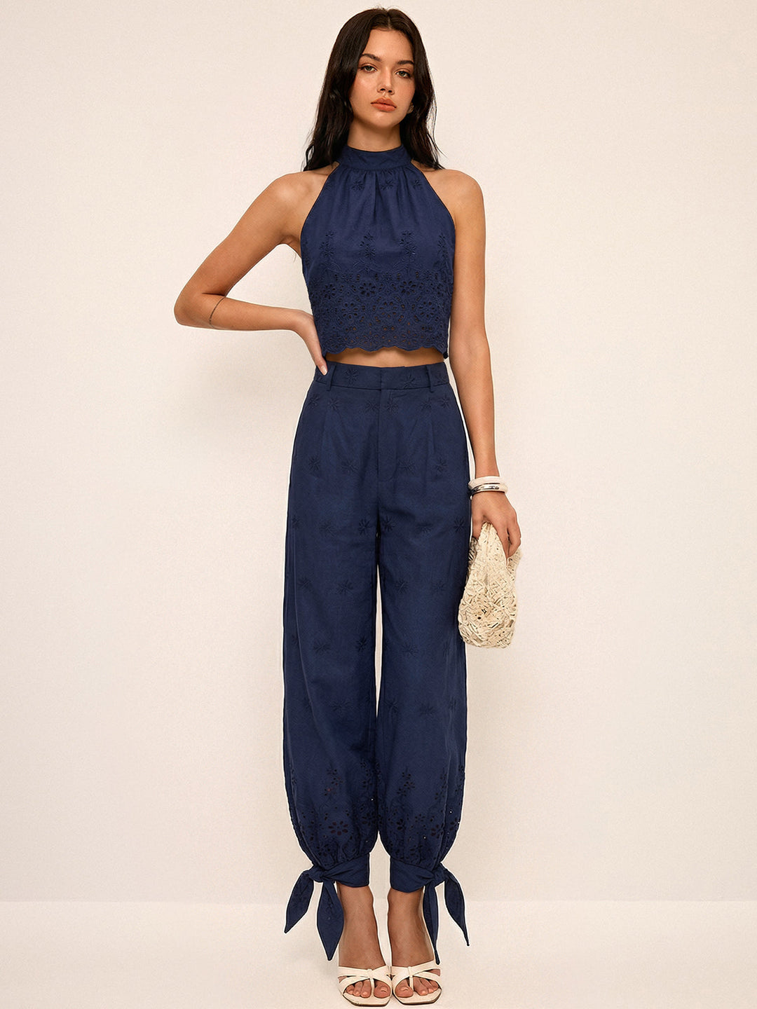 Completo donna elegante due pezzi primaverile con top traforato a maniche corte e pantaloni a vita alta con laccetti.