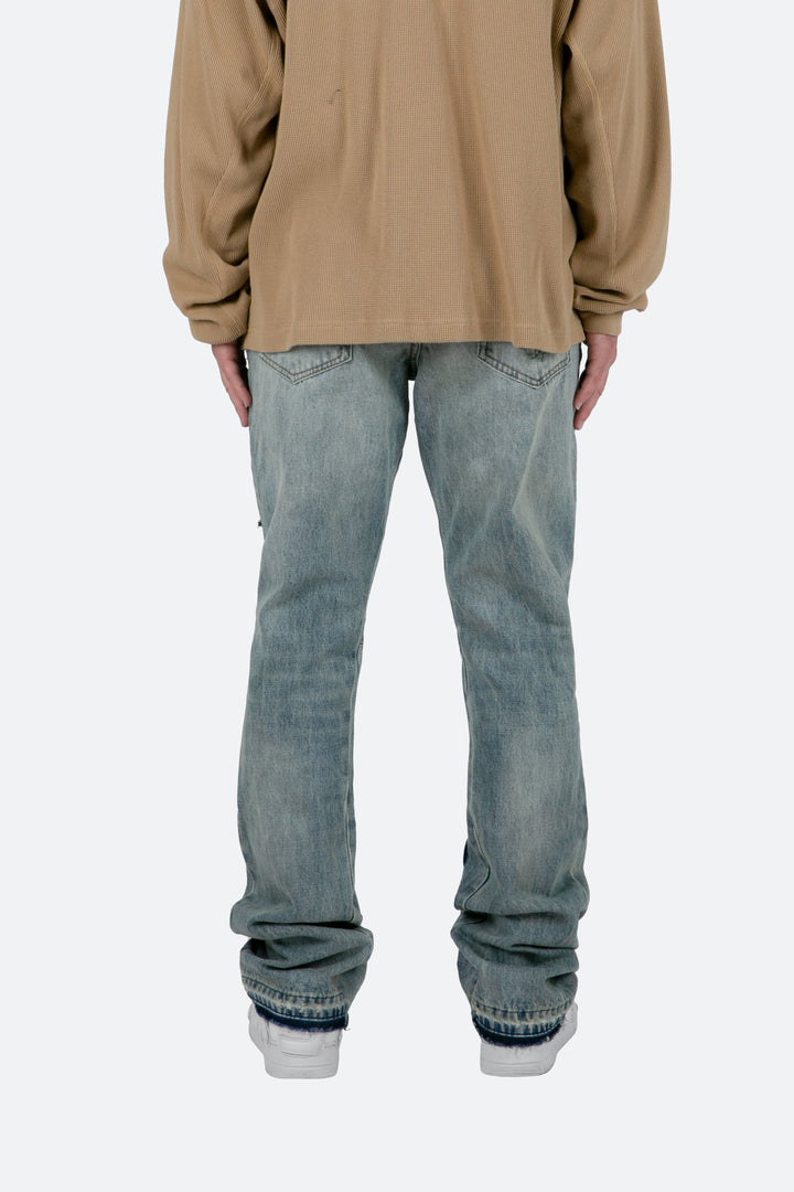 Dettaglio jeans uomo blu sfumati a zampa. Pantaloni denim slim fit con lavaggio moderno, ideali per ogni occasione.