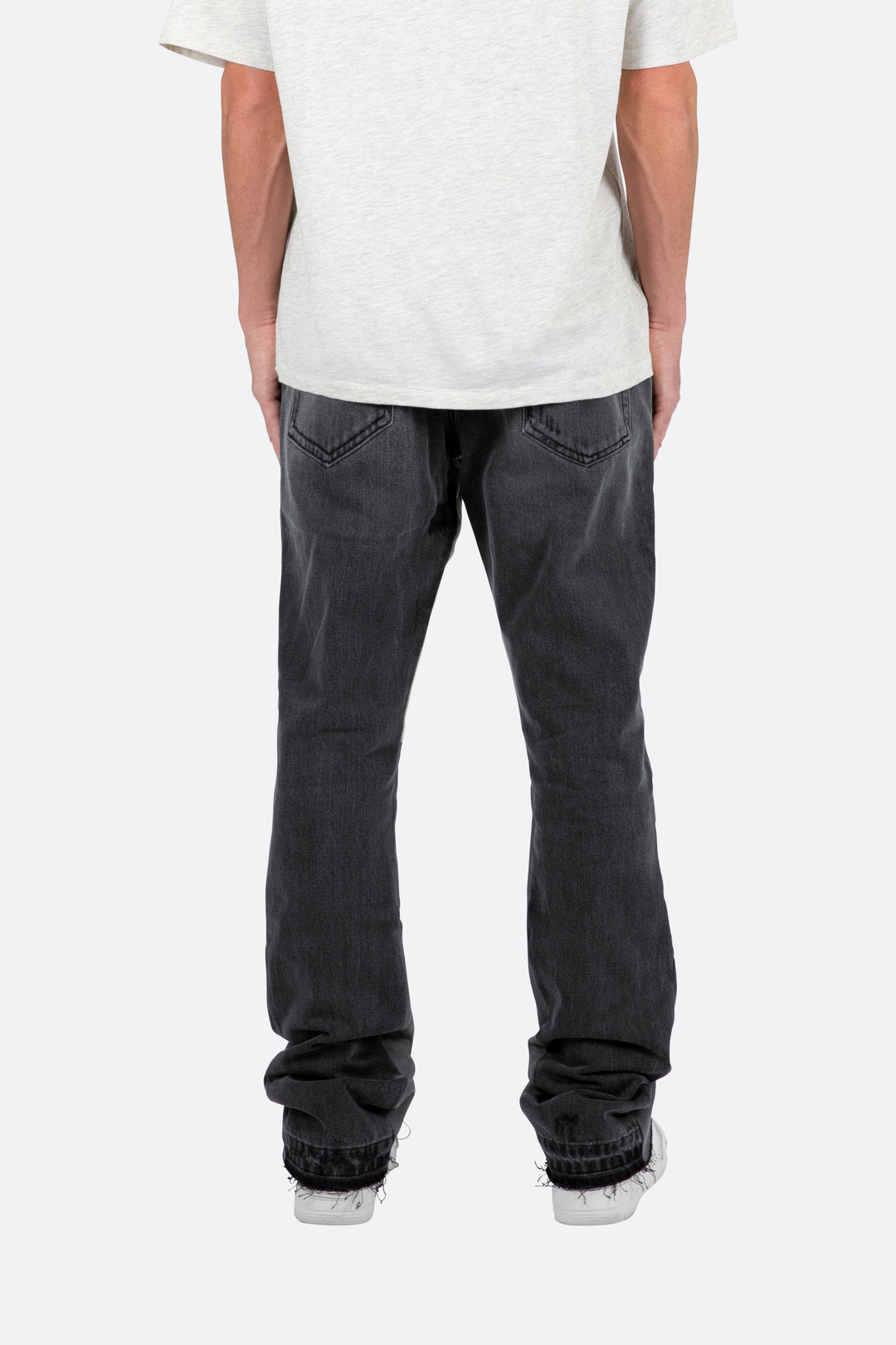 Pantaloni denim neri sfumati, vestibilità slim e fondo svasato. Jeans uomo a zampa per stile contemporaneo.