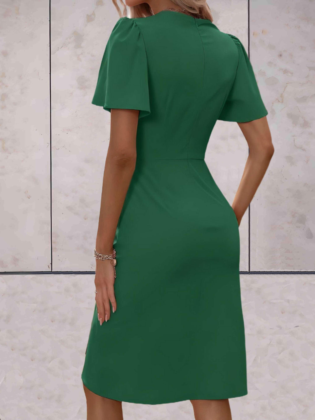 Dettaglio abito da donna slim fit con maniche fluide, stile elegante e avvolgente per un look moderno.
