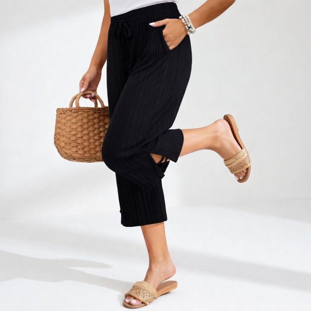 Dettaglio pantaloni da donna fluidi a vita alta, estivi ed eleganti. Massima comodità per un look moda casual.