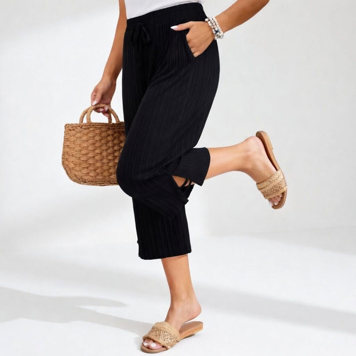 Dettaglio pantaloni da donna fluidi a vita alta, estivi ed eleganti. Massima comodità per un look moda casual.