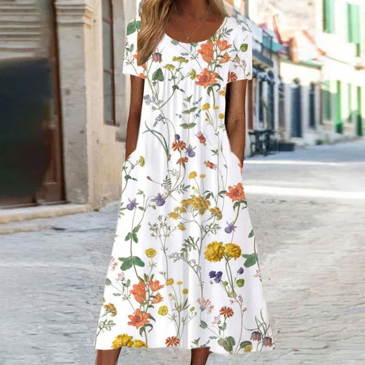 Abito estivo lungo donna con stampa floreale colorata. Modello svasato e fresco, ideale per look eleganti.