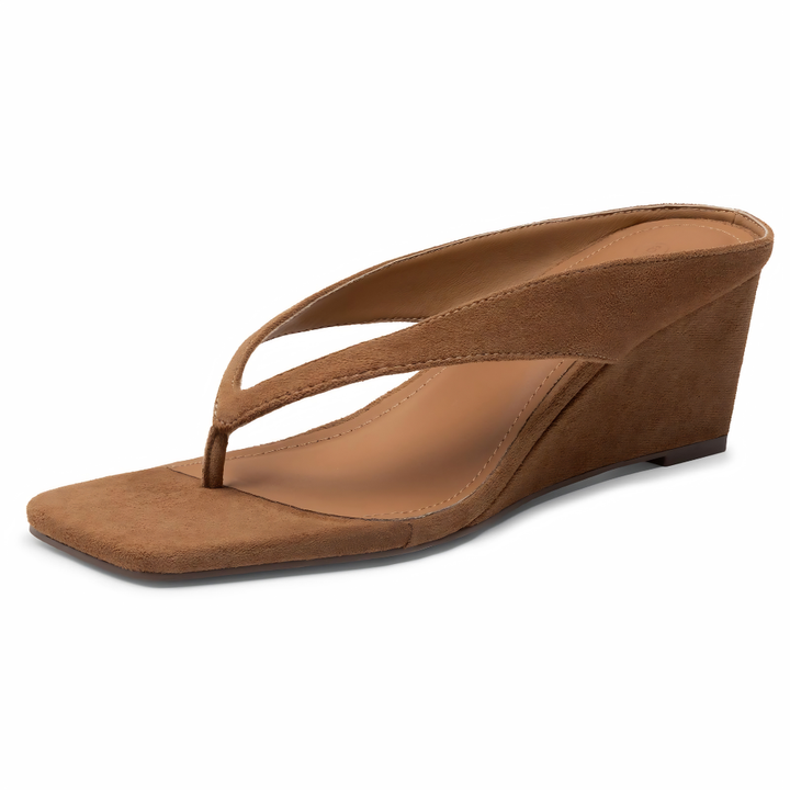 Sandali infradito con zeppa ai piedi di una donna, calzature estive confortevoli e alla moda.