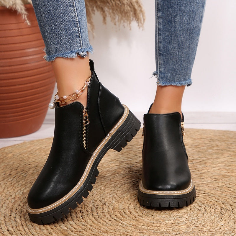 Stivaletti donna neri con zip laterale e suola platform, perfetti per look autunnali e invernali alla moda.