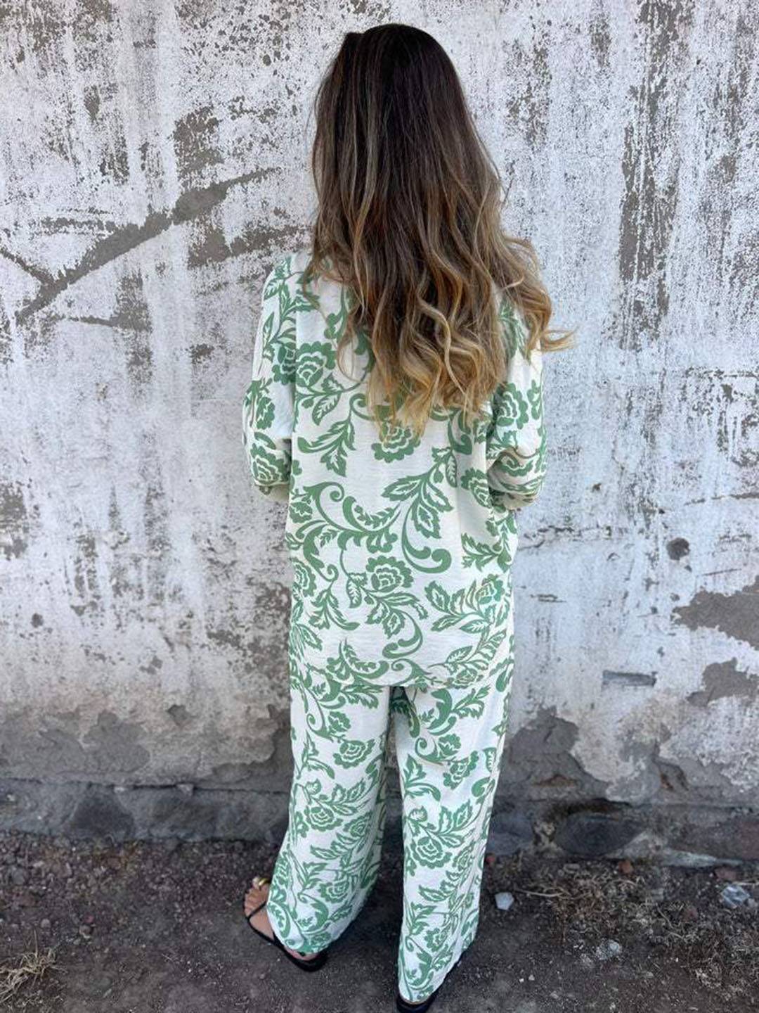 Outfit estivo donna per vacanza, completo due pezzi nero/verde con vivace stampa foglie e pantaloni ampi.