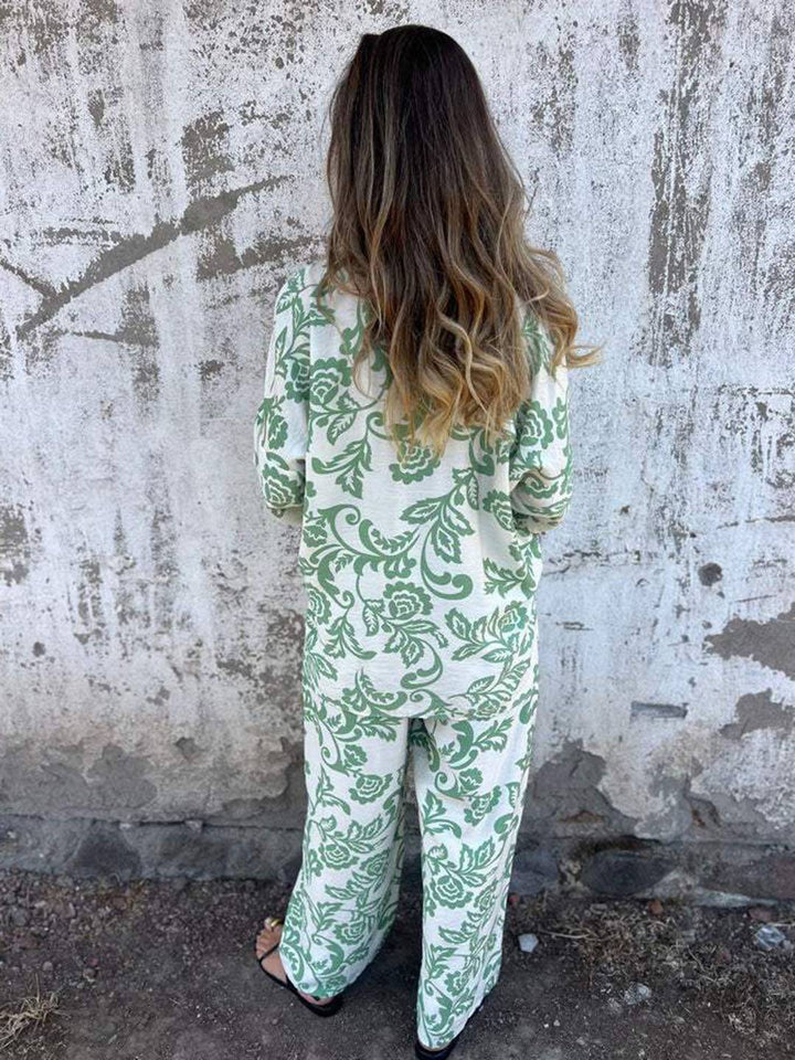 Outfit estivo donna per vacanza, completo due pezzi nero/verde con vivace stampa foglie e pantaloni ampi.