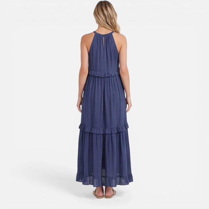 Donna indossa abito maxi estivo fluido a balze, senza maniche, per un look fresco e alla moda.