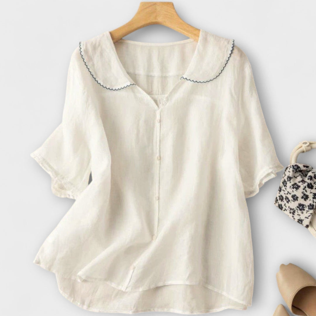 Blusa donna blu con colletto Peter Pan e maniche a volant, perfetta per la stagione estiva.